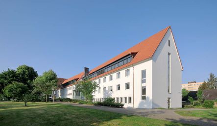 Langes, weißes Haus mit vier Stockwerken und rotem Spitzdach Foto der Außenstelle Dortmund, Kommende Dortmund