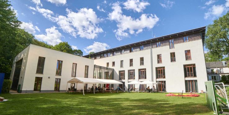 Vierstöckiges weißes Haus mit zweistöckigem Anbau und Rasen im Vordergrund Foto der Außenstelle Haltern Am See, Könzgen Haus